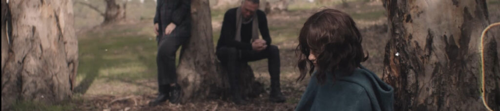 frame de una chica sentada en el bosque